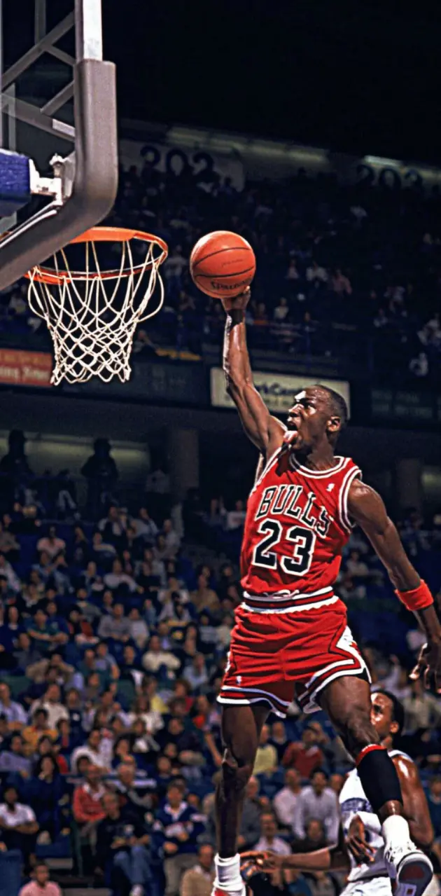 Download A Basketball Player Is Dunking Wallpaper